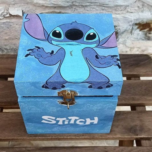 Blue money box with a cartoon character on a wooden surface, with lock and keys