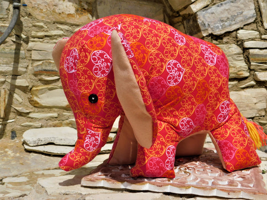 Decorative elephant with a pink and orange pattern on a stone surface