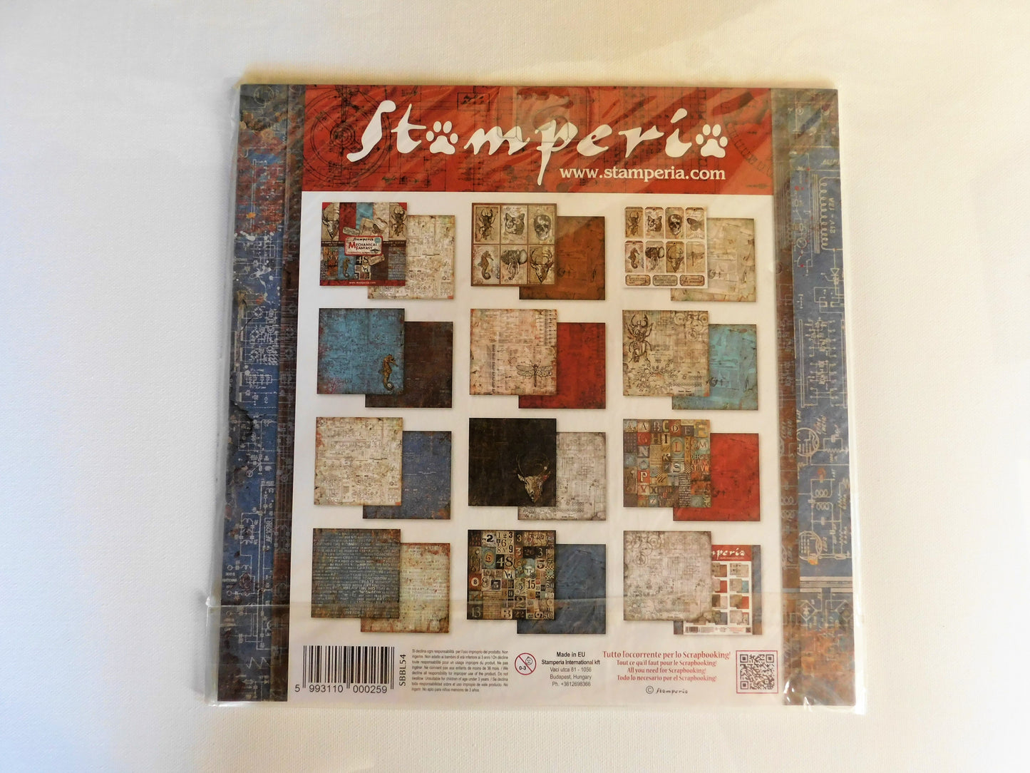 A Stamperia stamping book or booklet on a plain white background, showing a cover with a collage of textured paper squares and the Stamperia brand name at the top.