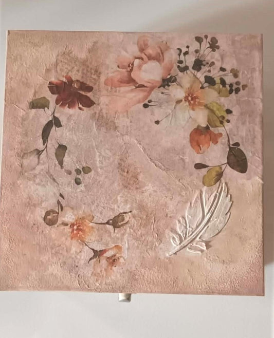 Floral design on a textured pink background with a feather