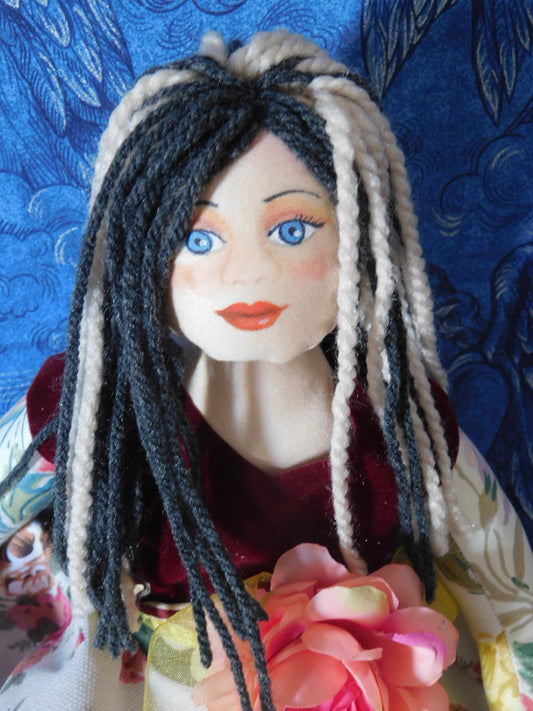 Handmade fabric doll with two-color woolen hair and a floral dress