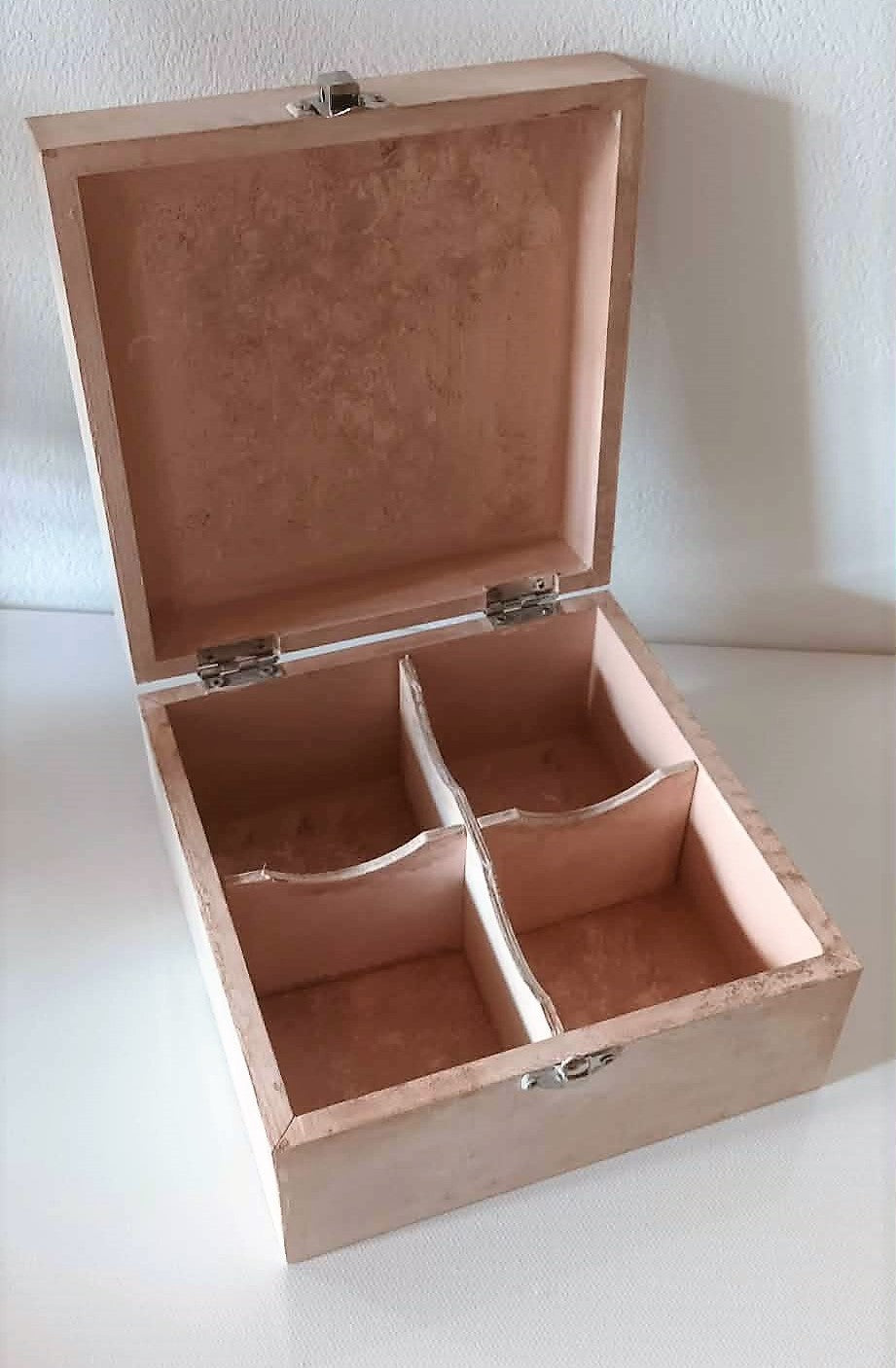 small handcrafted wooden jewelry box with four compartments .