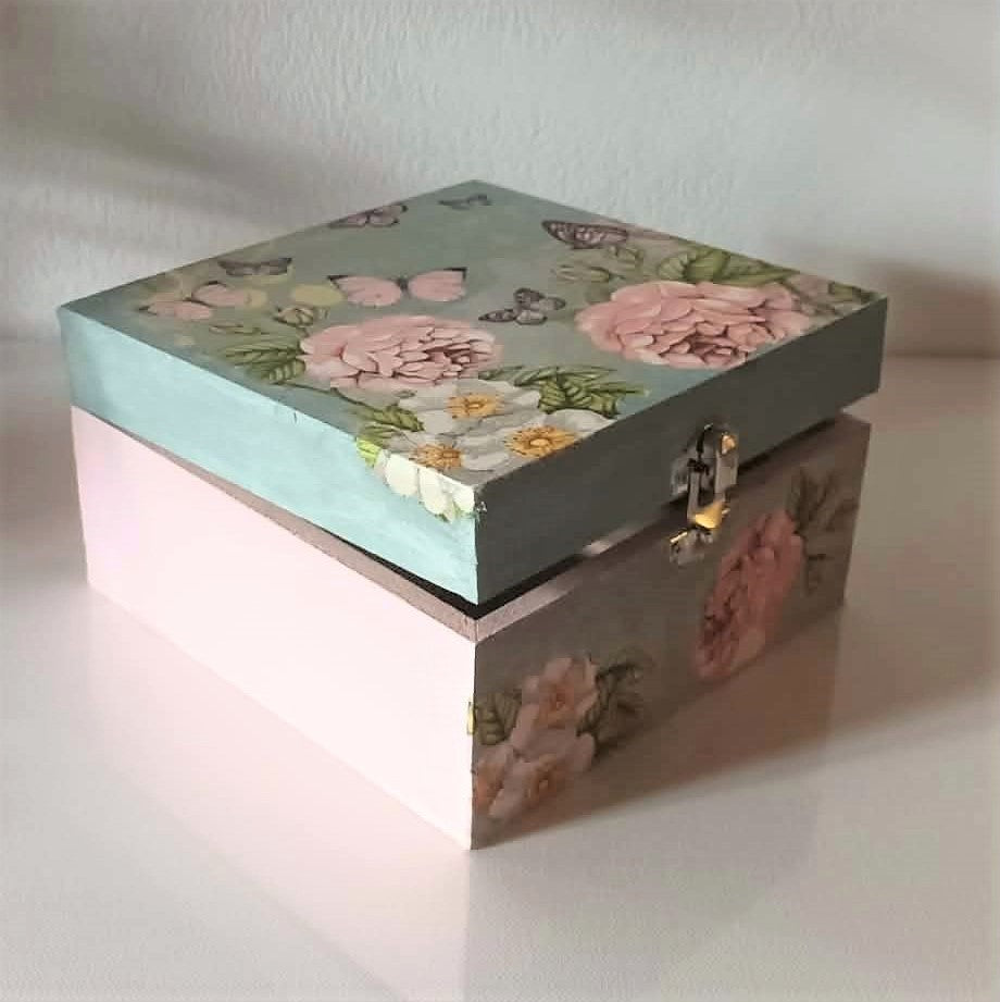 small handcrafted wooden box with floral design on a light background