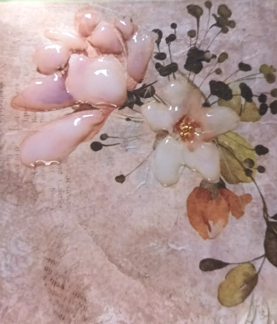 Close-up of a floral arrangement with pink flowers and green leaves on a textured surface.