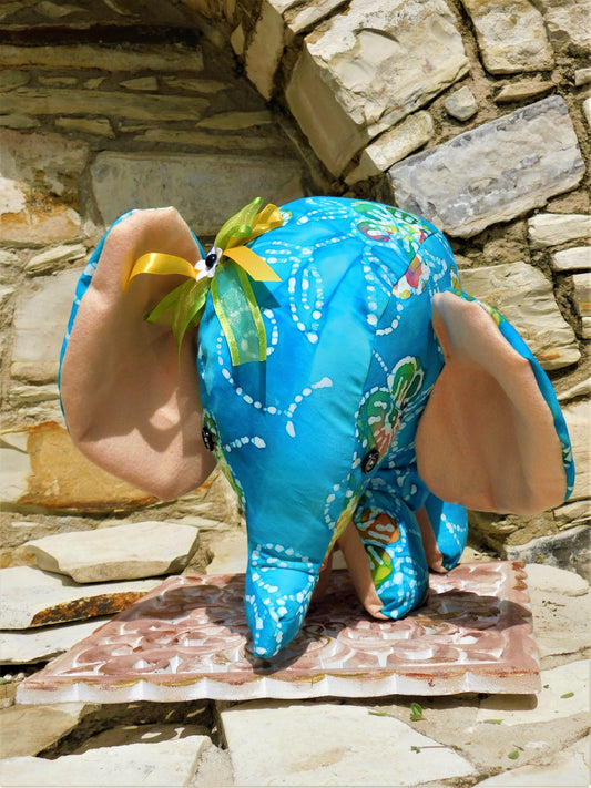 Blue elephant plush toy with floral patterns on a stone surface