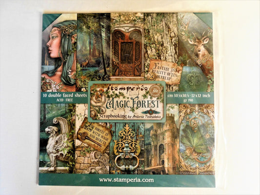 A packaged sheet set of decorative scrapbooking paper sheets titled 'Magic Forest' by Antonis Tzanidakis, featuring a collage of woodland-themed designs including a woman's profile, a deer, a tree trunk, a gate, and vintage-style text panels on a white background.
