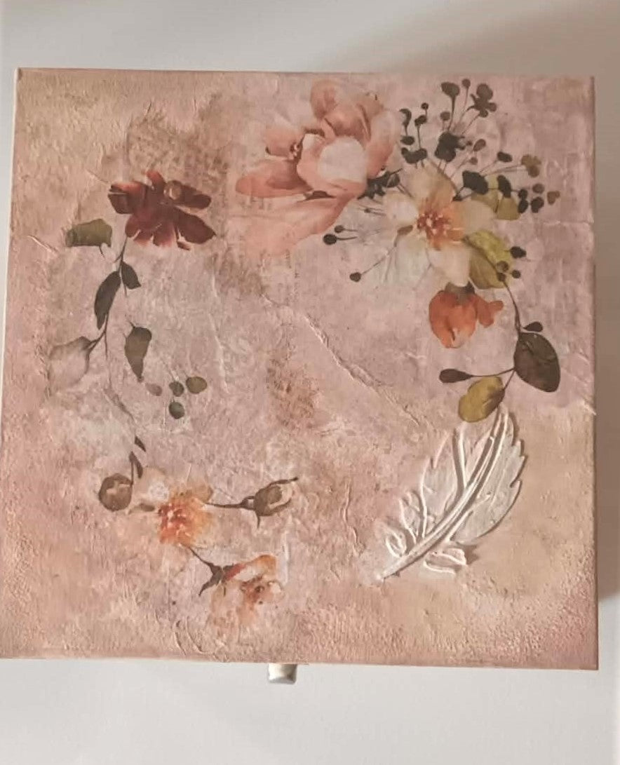 Floral design on a textured pink background with a feather